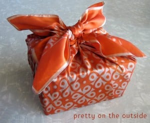 present wrapped in an orange scarf