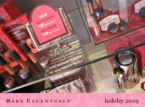 lip gloss and eyeshadow containers on counter with pink makeup pricing signs