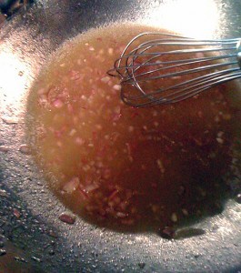 whisking the vinegar with the shallots, honey and salt inside a large bowl