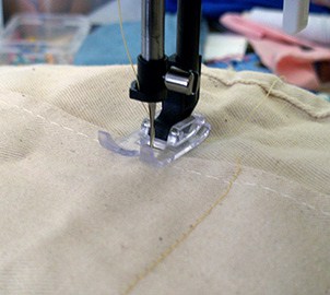 Stitching the white canvas work belt in the sewing machine