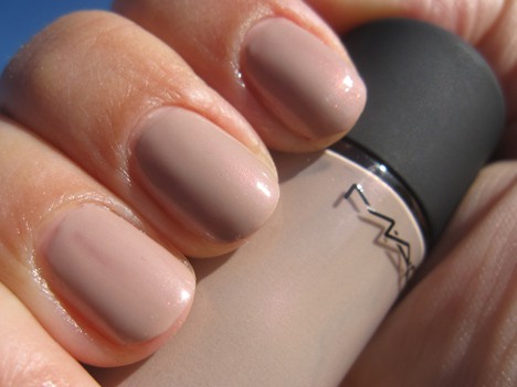 A hand with a nude fine pink nail polish holding a nail lacquer endless night shade