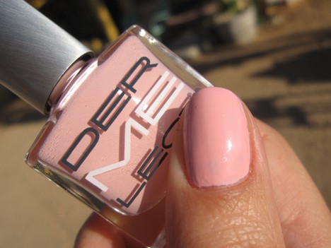 A hand with a light milky pink nail polish