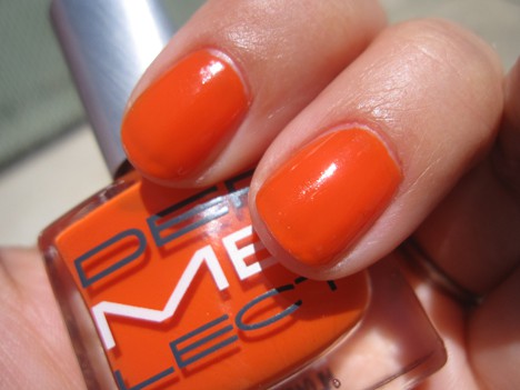 A hand with a vibrant orange nail polish
