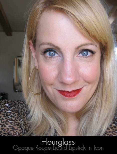 A blonde woman smiling wearing the hourglass opaque rouge liquid lipstick in icon with a rich blue-based blood red shade lipstick