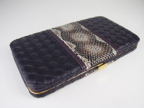 Housing of the palette with a deep purple textured clutch with a faux snakeskin accent on a white background