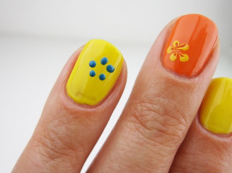 A nail yellow polish with 5 dots onto the surface of one nail while other orange nail polish has a petal art