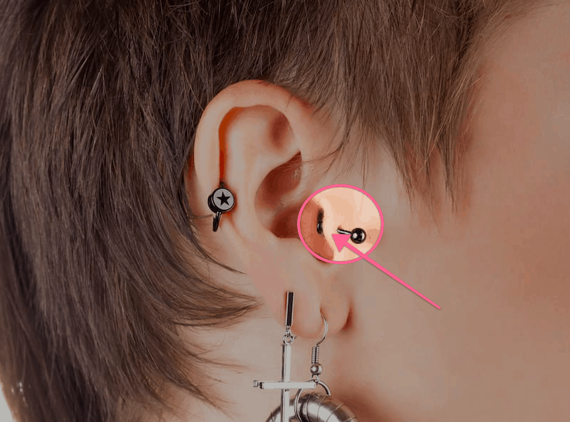 šipka ukazující na místo, kde je tragus na uchu