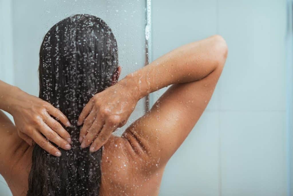 tan woman taking a shower after tanning