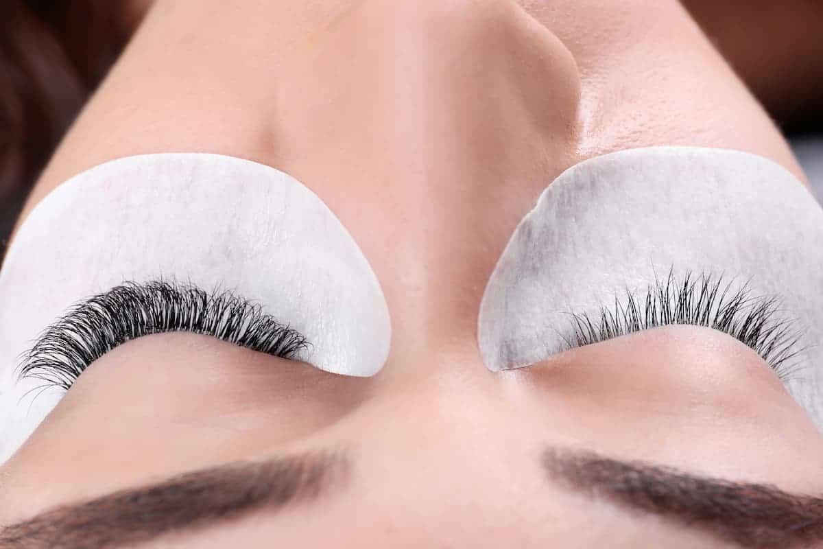 Woman with full eyelash extension style on left eye and no lash extensions on right eye
