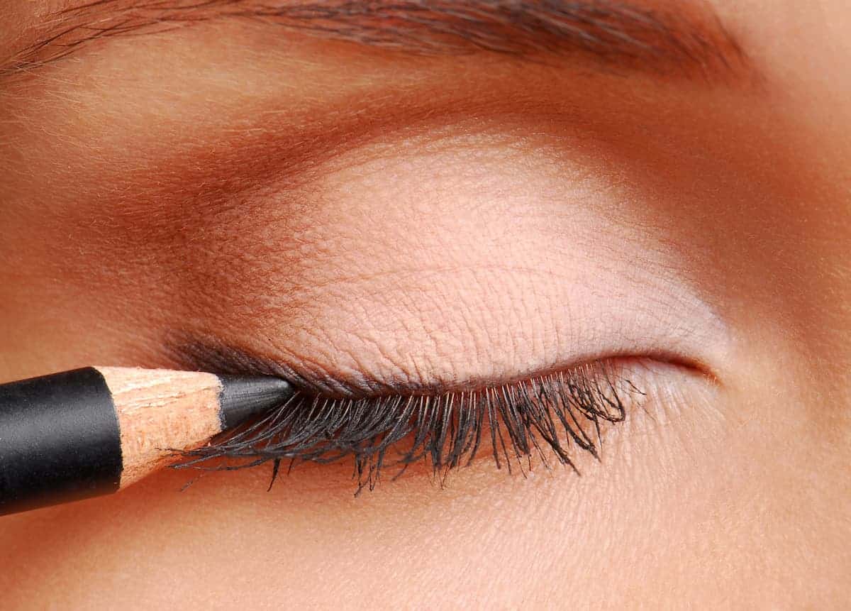 close up of woman's eye having pencil eyeliner applied