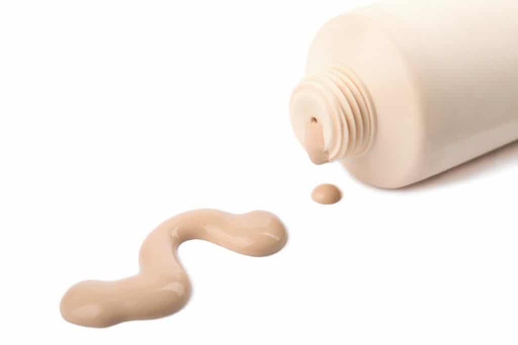 bottle of fair toned silicone foundation squirted out on a white background