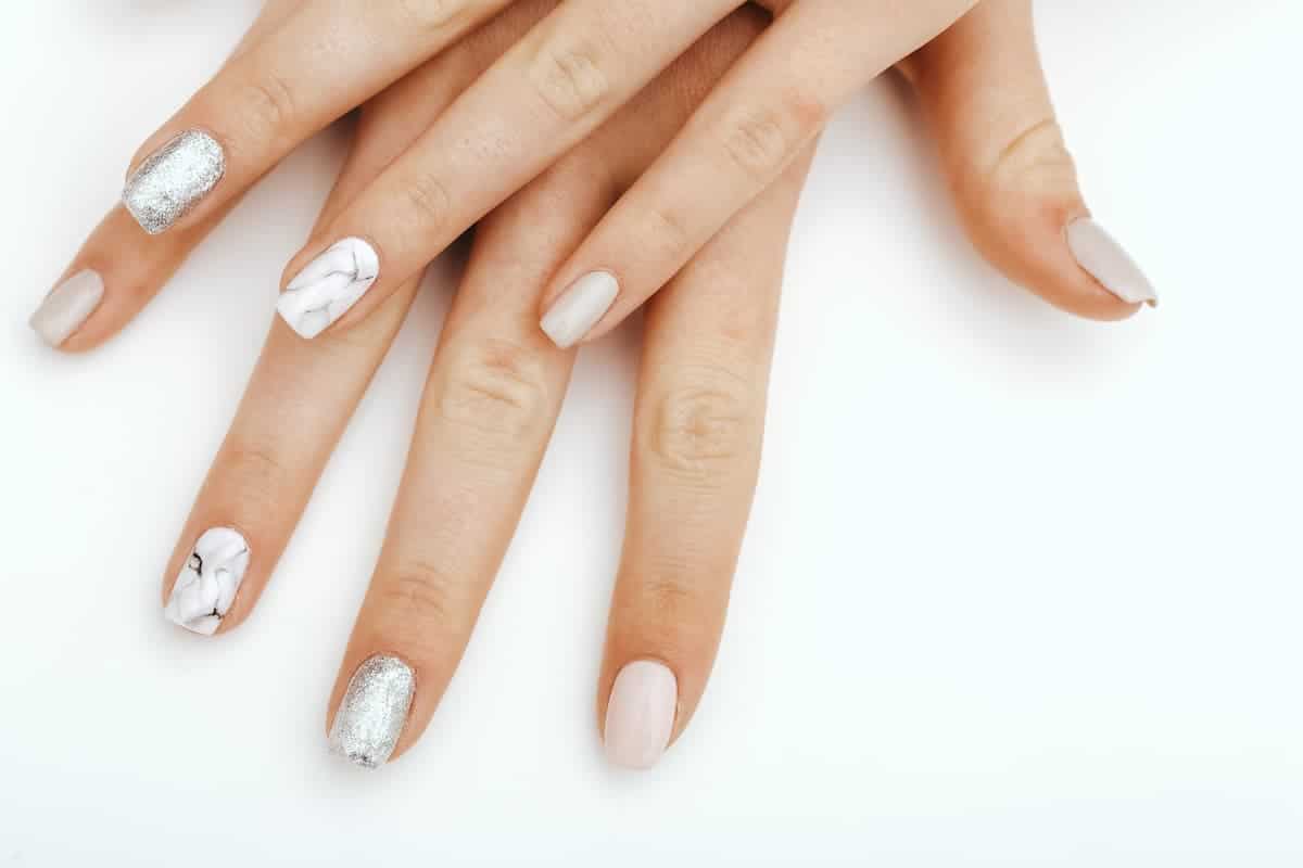 hands with a white and silver gel manicure