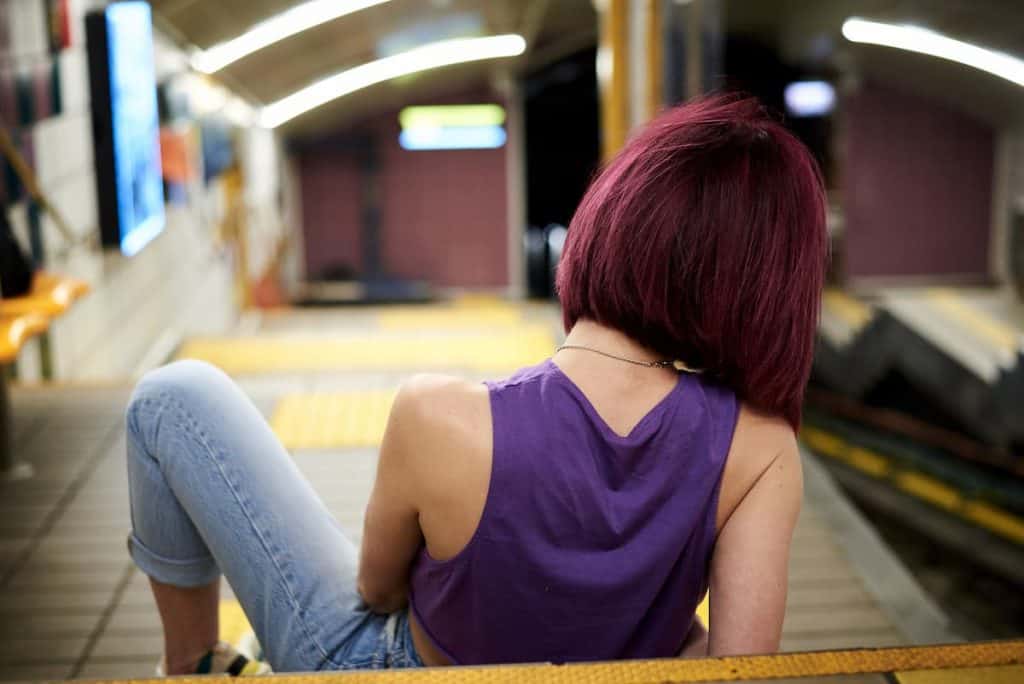 Woman in purple shirt with burgundy hair sitting