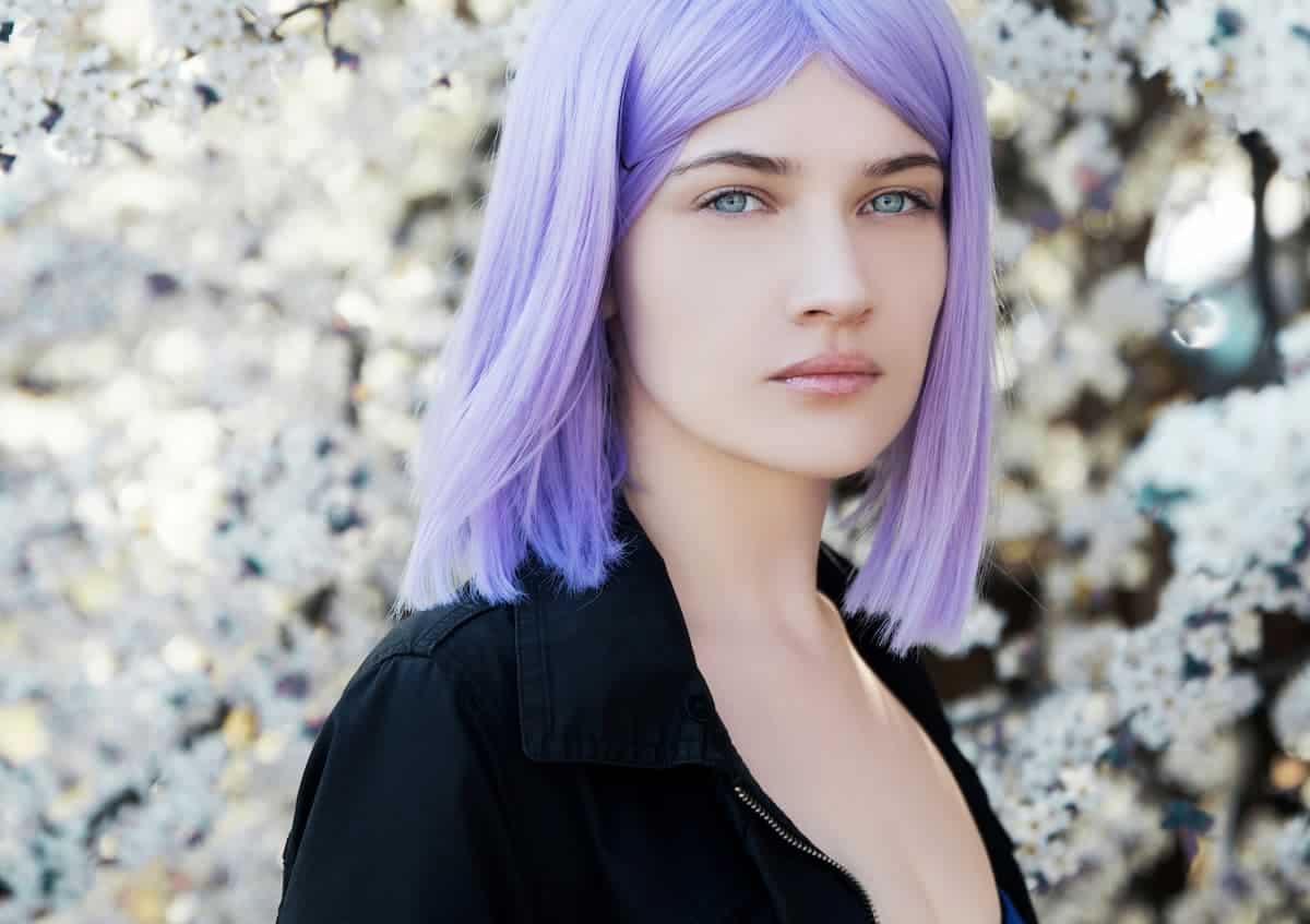 Beautiful woman staring at the camera with medium length light purple hair