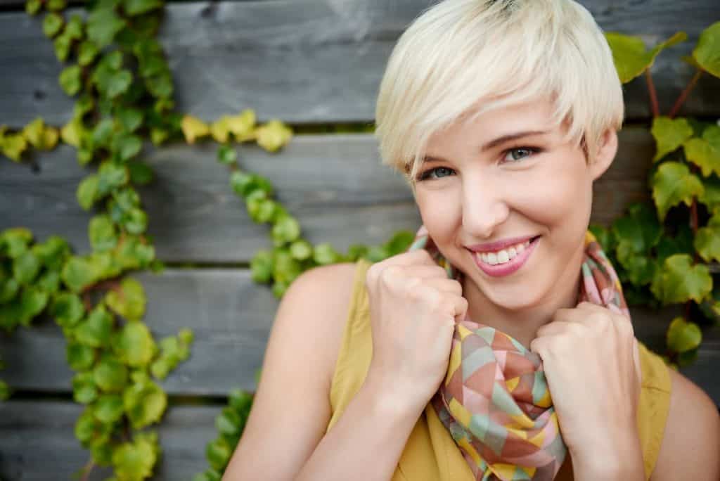 Smiling woman with short bleached blonde hair