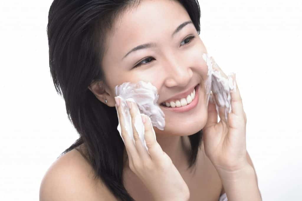 Woman lathering soap on her face