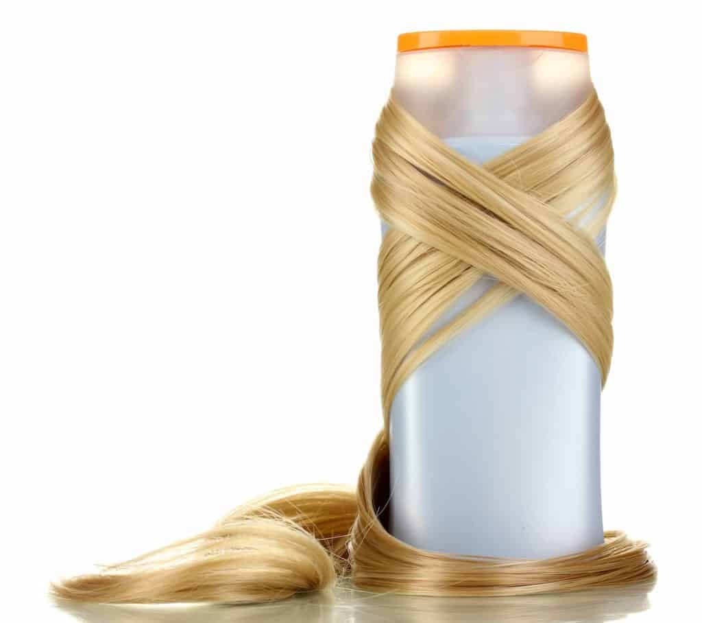 white shampoo container wrapped with blonde hair extensions