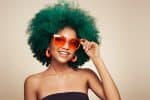 beautiful green-colored hair African American wearing orange sunglasses and earrings