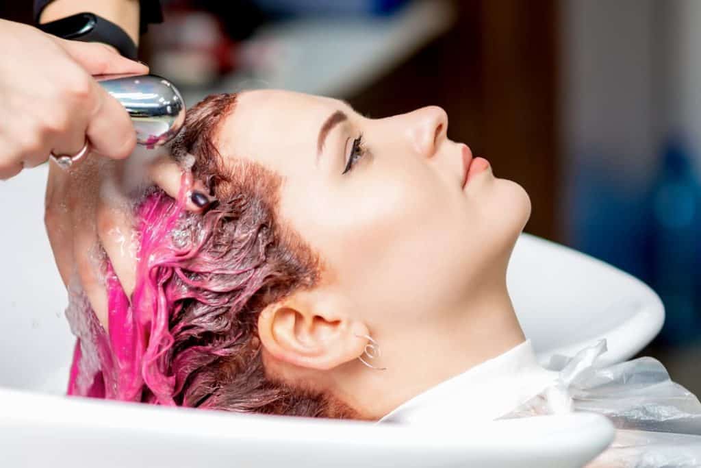 closeup view of young woman having her colored hair washed in a beauty salon