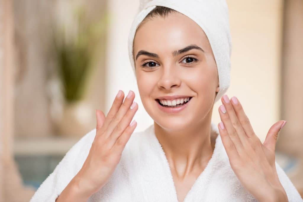 woman wearing bathrobe and head towel showing her perfectly clean face