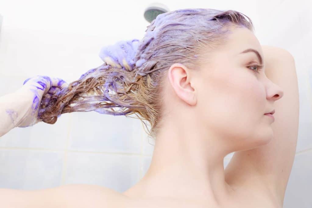 woman applying toner shampoo on her hair
