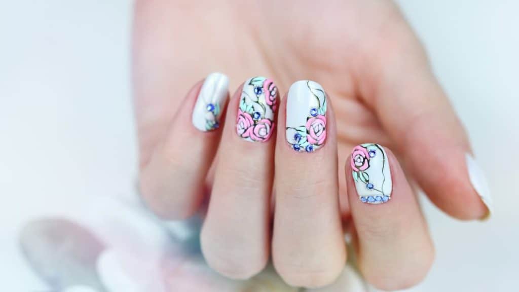 manicured finger nails with cute pink flower nail art