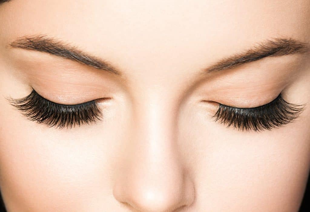 A close up of a woman's closed eyes with false lashes.