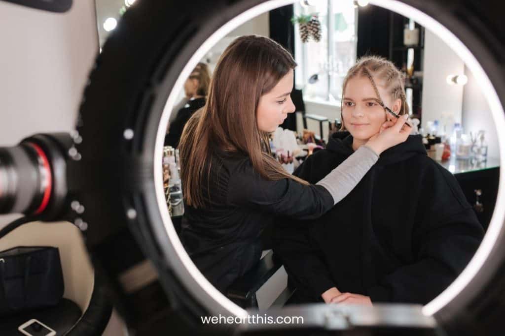 a make up artist applying eye make up to her client with the best ring light for make up for the best lighting