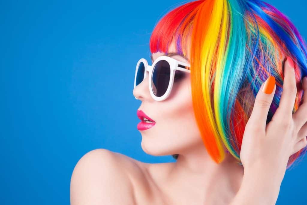 a young girl wearing a sunglasses and a short synthetic colorful hair