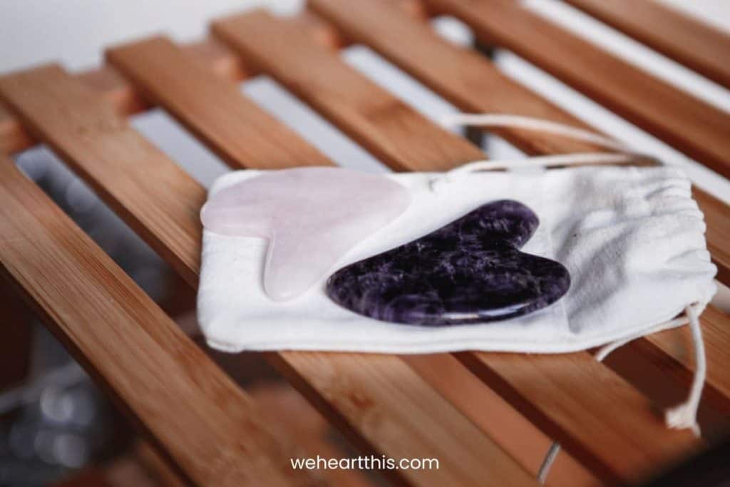 two gua sha laid in a small pouch placed in a wooden chair
