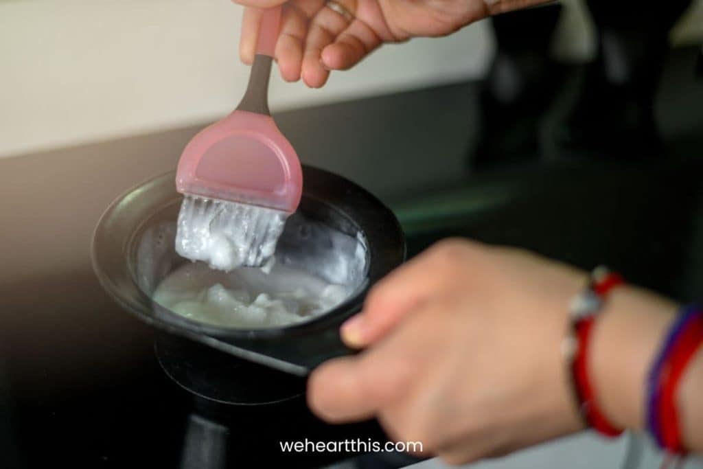 a woman mixing a semi permanent hair dye using a black mixing bowl