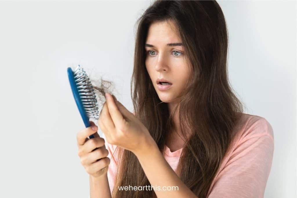 A woman surprised having hair loss in her hair brush