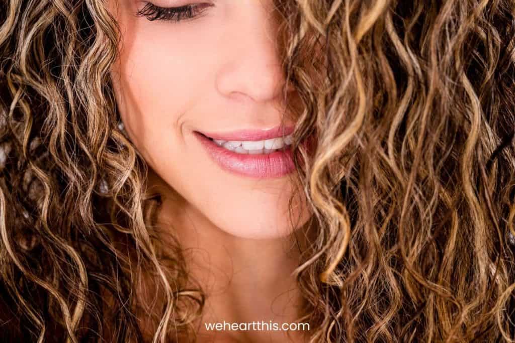 a close-up image of a young girl with low porosity curly hair