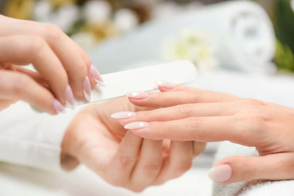 A manicurist doing the nails of a woman at the salon