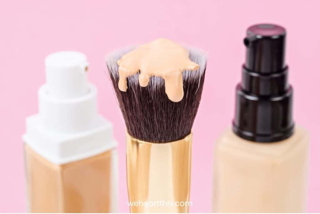 Two foundations and a brush in a pink colored background