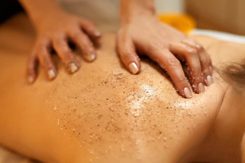 A specialist doing a body scrub to a woman