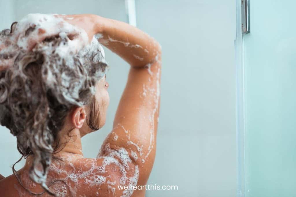 a close-up image of a woman washing her scalp with the best shampoo for smelly scalp