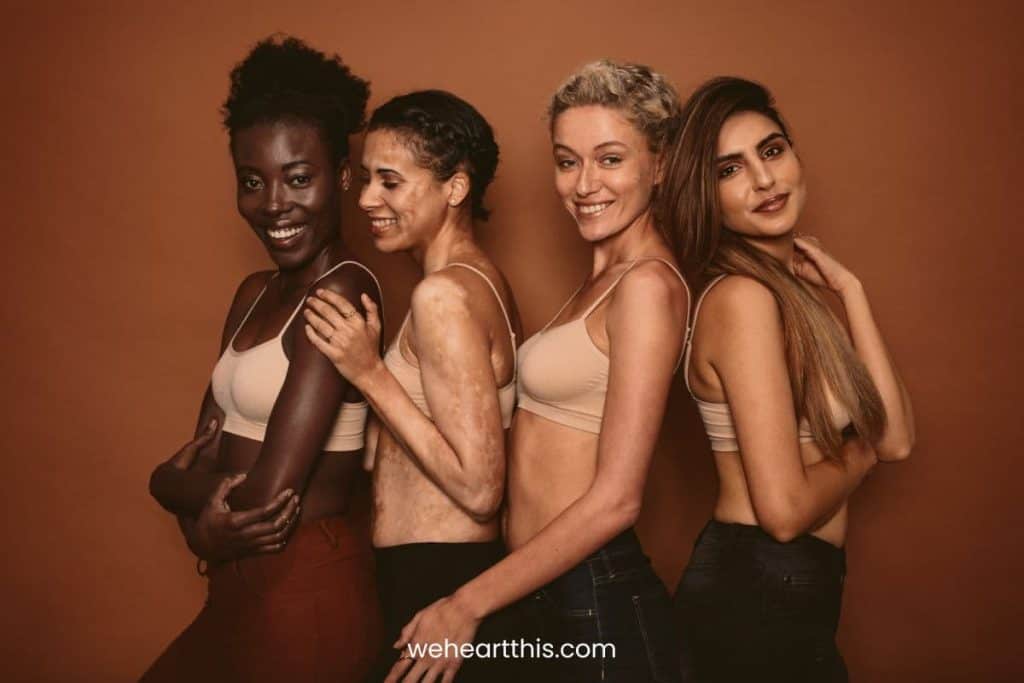 four woman posing at the camera highlighting their skin color differences