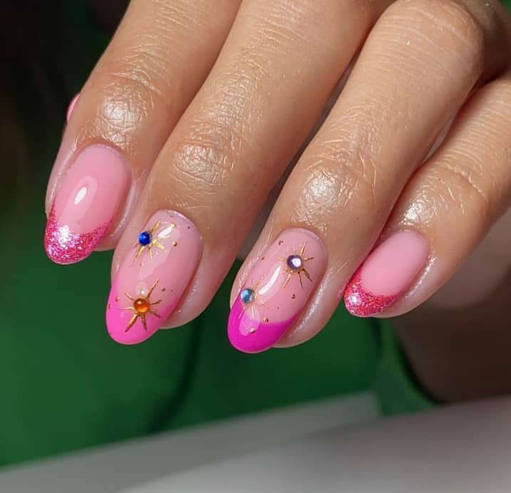 A woman's with pink french tip nails and gold stars on them