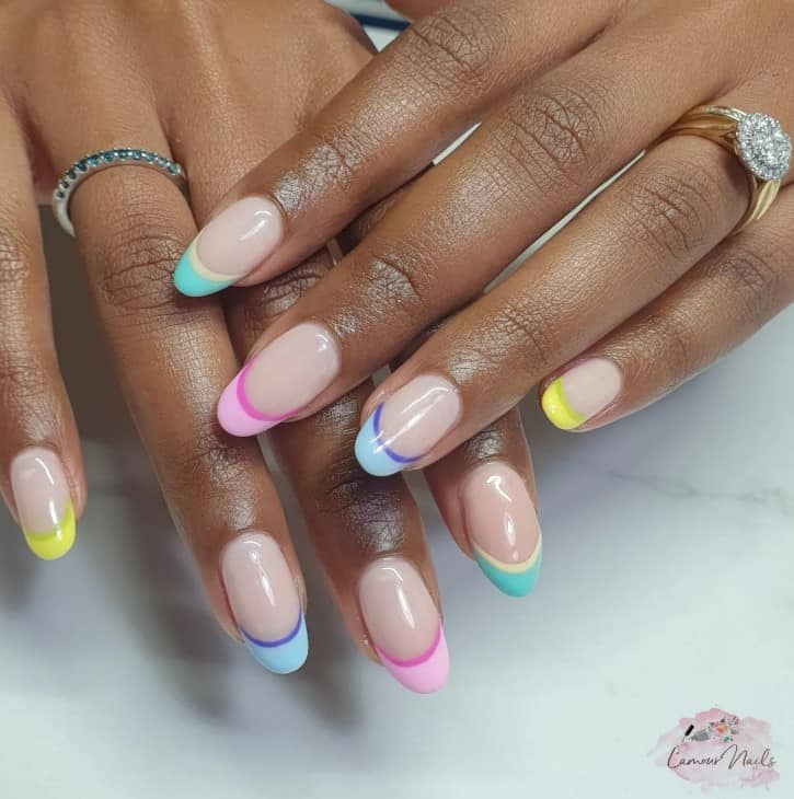 A woman's hands with colorful two-toned french tip nails.