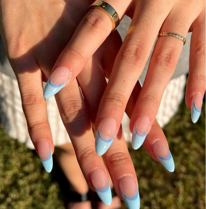 A woman's hands with two-toned blue french tip nail design