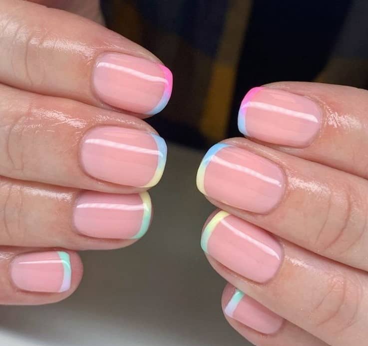 A woman's pastel rainbow stripe thin french tip nails.
