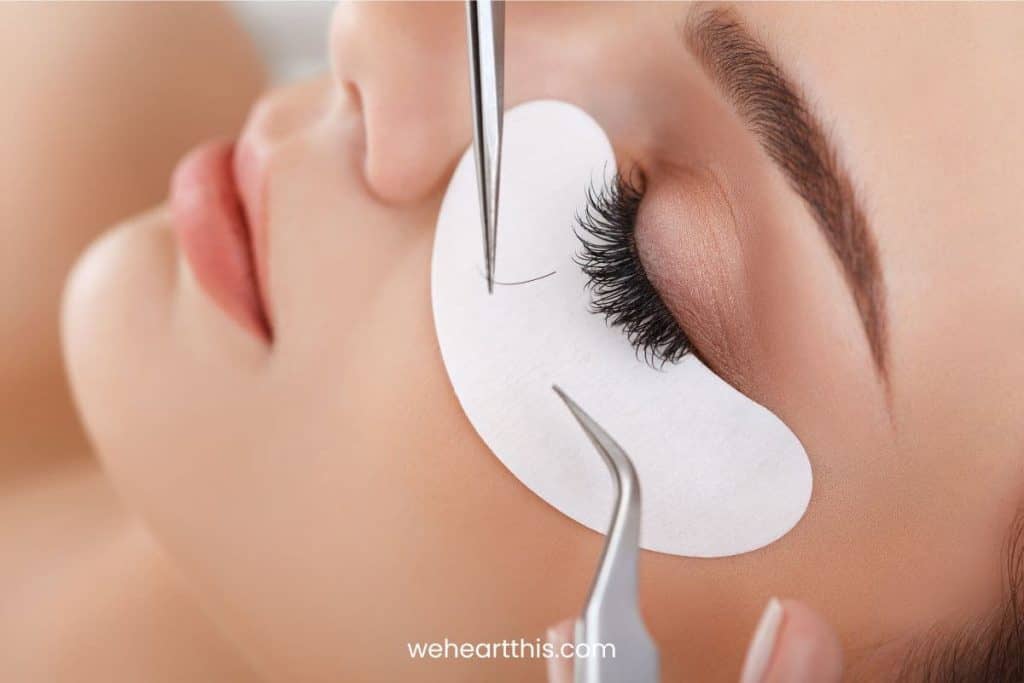 A lash artist applying lash extensions to the woman's eye