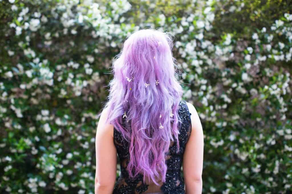 woman with with a long curly hair colored with lilac