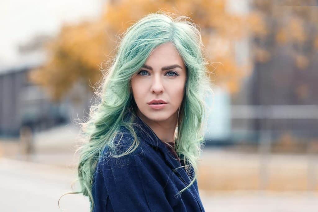 outdoor photo of a beautiful woman with mint green hair