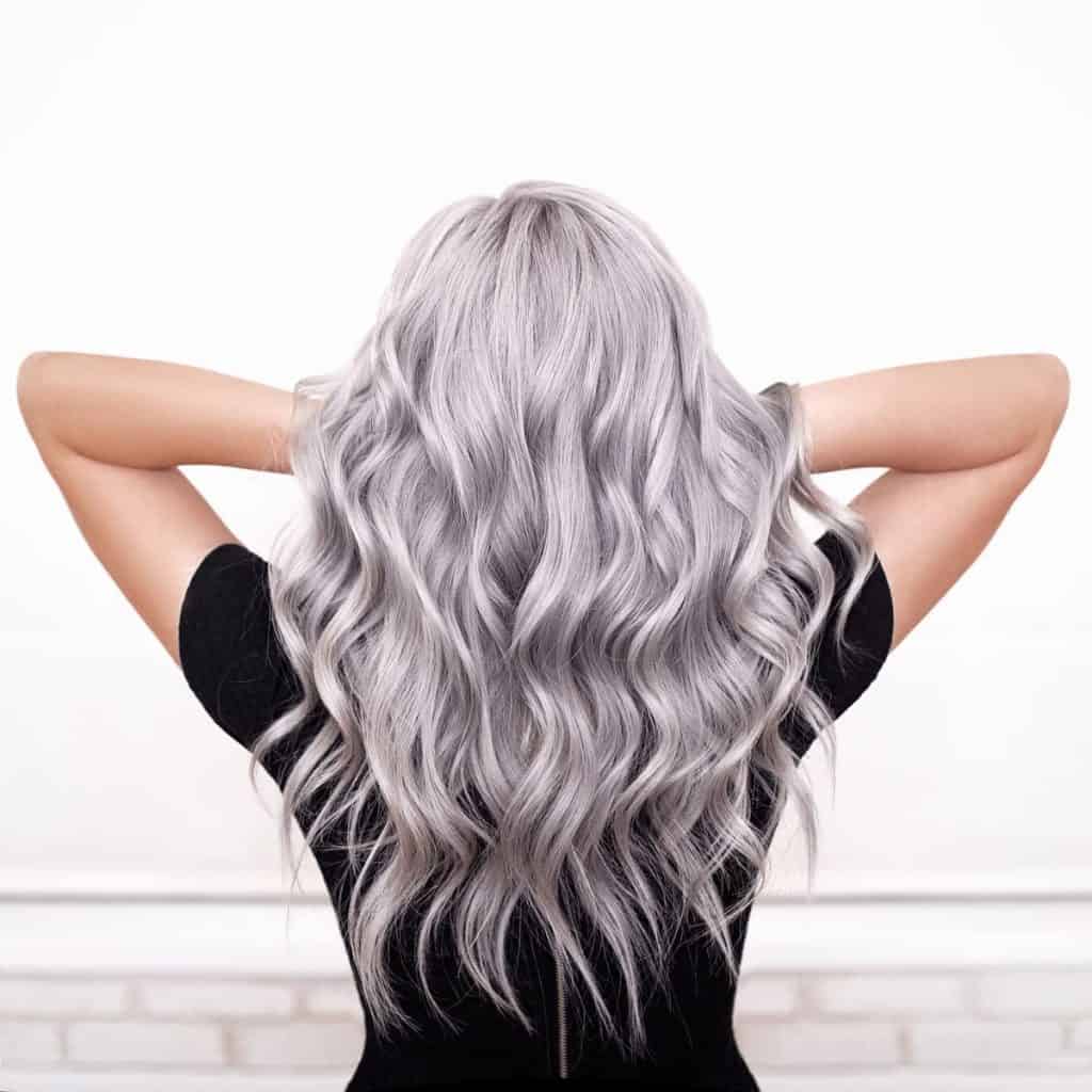 close up photo of a woman's beautiful hair styled with loose curls and silver color