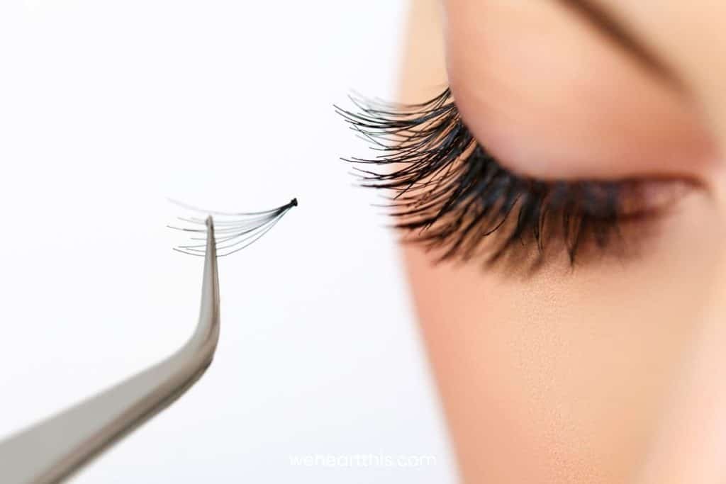 A woman applying eyelash extensions