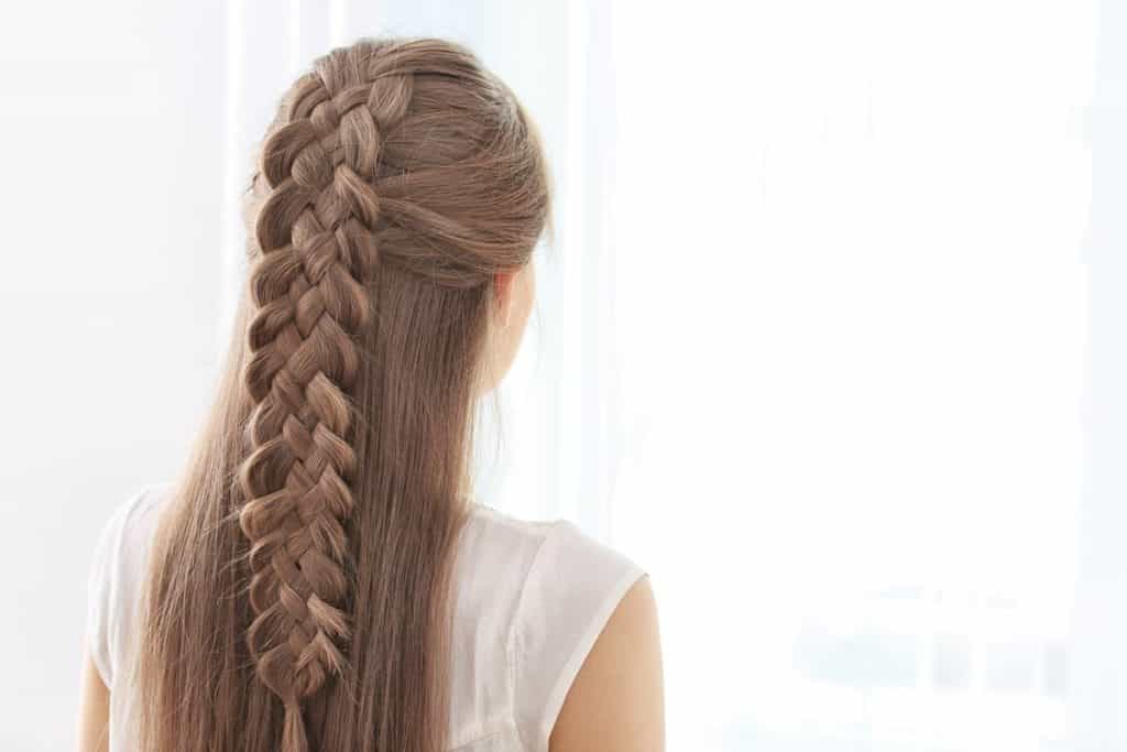 photo of a woman with a long half braided hair on a white background