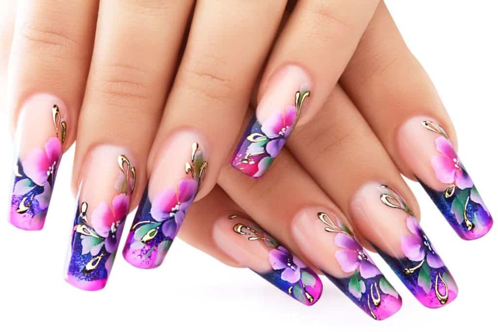 Nails of a woman with a colorful floral design isolated in a white background