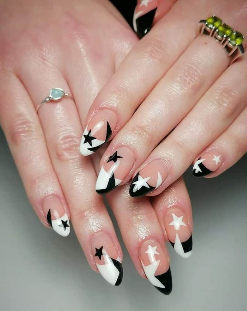 A woman's hands with a nude nail polish that has beautiful black and white rock star nail design